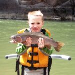 Child holds rainbow trout