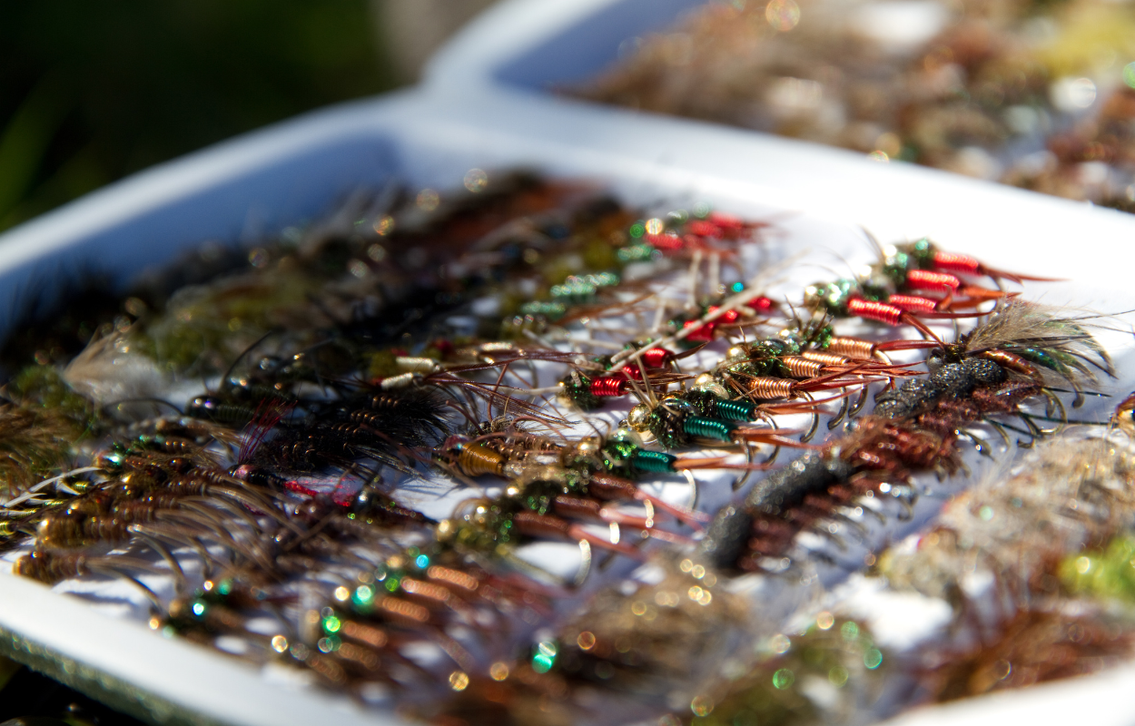 A gray fly box full of nymphs for fly fishing