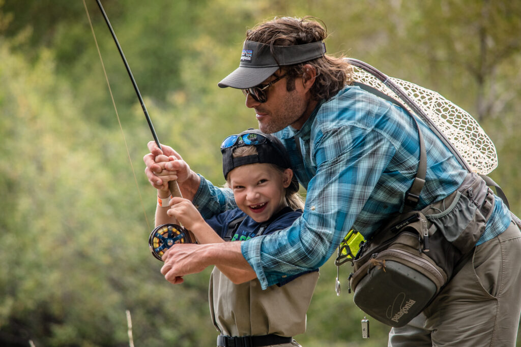 Man teaches child how to fly fish