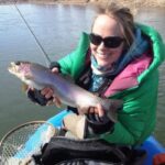 Women holds Rainbow Trout while float fly fishing