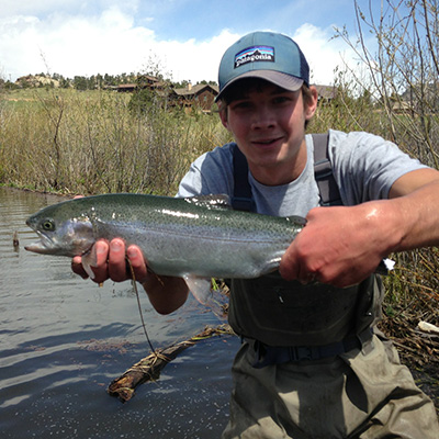 Teen angler holding rainbow trout
