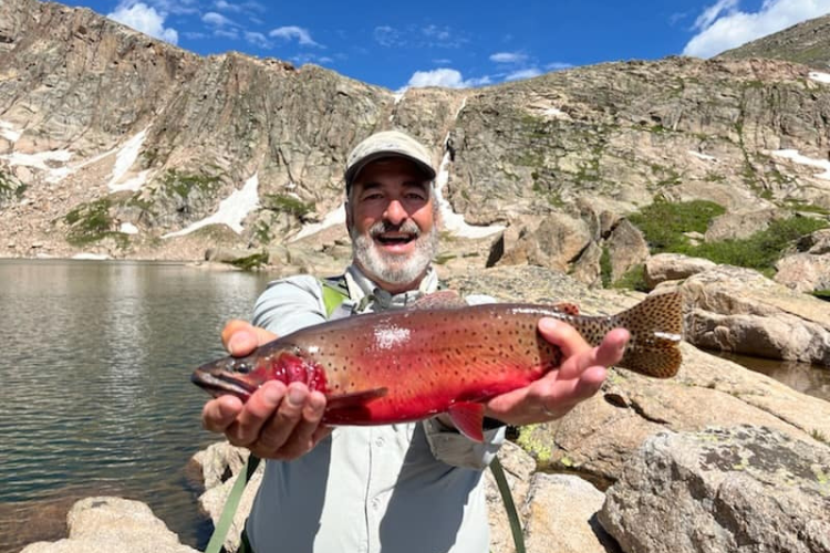 Fly Fishing Trips Rocky Mountain National Park Man holds cuuthroat trout in Rocky Mountain National Park