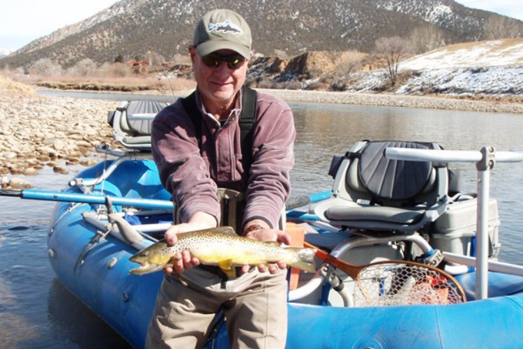 Man holds Brown Trout while fly fishing on the Colorado River