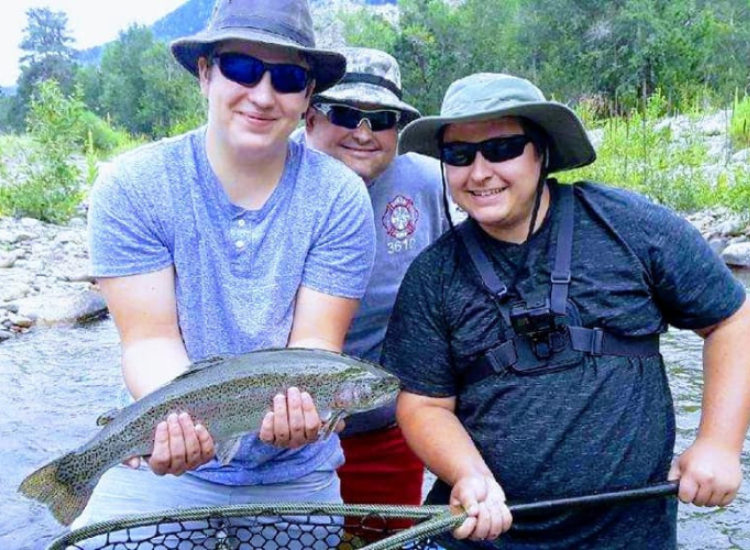 Fly fish Colorado Three men with sunglasses on hold a rainbow trout