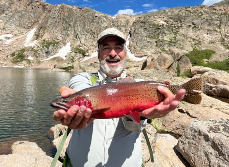Man holds Cutthroat Trout while fly fishing in Rocky Mountain National Park