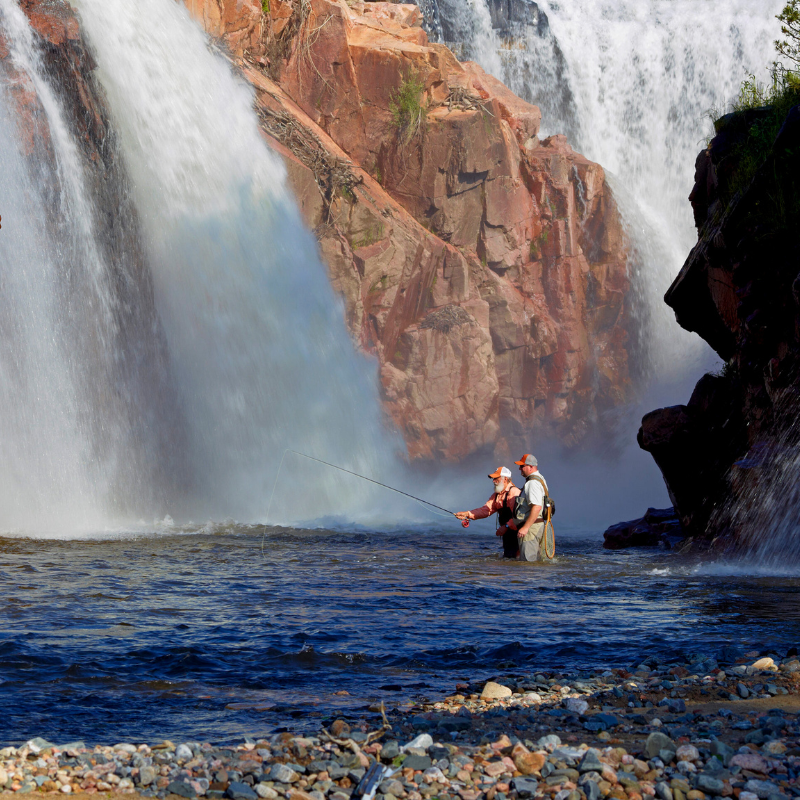 two anglers fly fish below waterfalls in Estes Park, Colorado