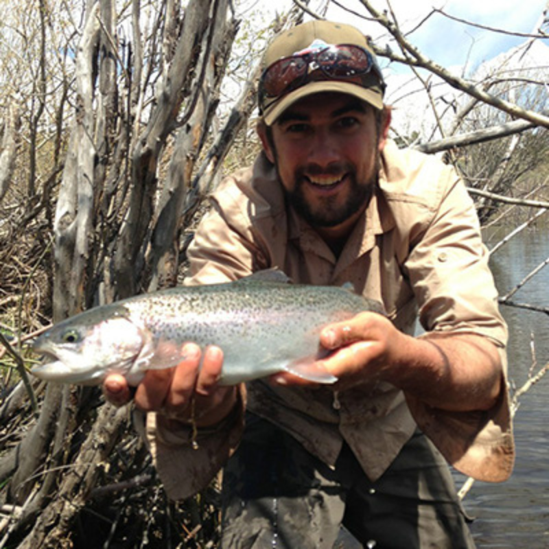 man holds rainbow trout while fly fishing near Estes Park, Colorado