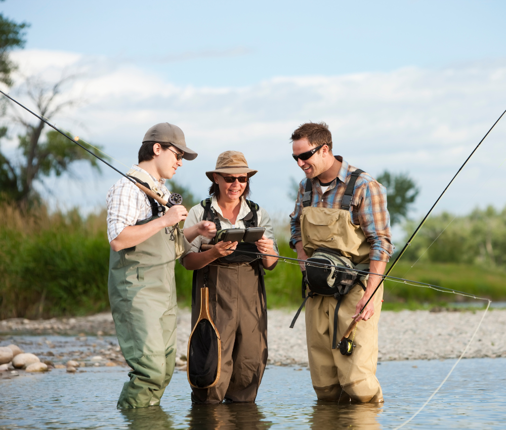 three anglers standing together with waders on in a river