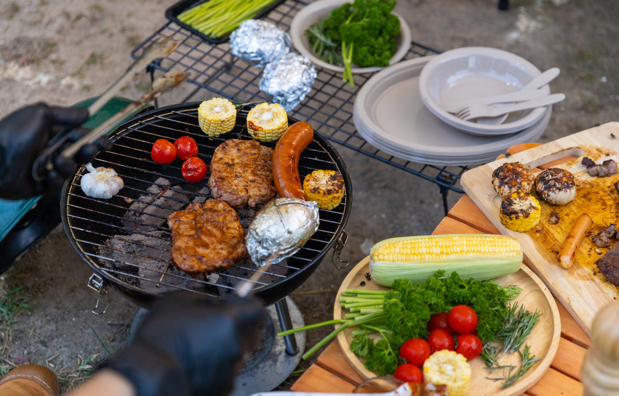 a grill with meat and vegetables while camping