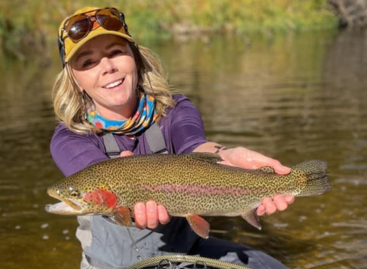 women holds large rainbow trout