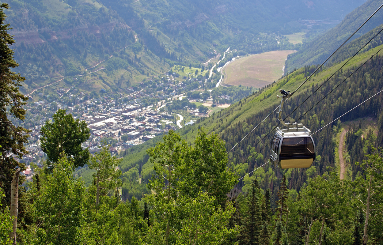 telluride colorado in the distance with a ski resort gondola in the foreground
