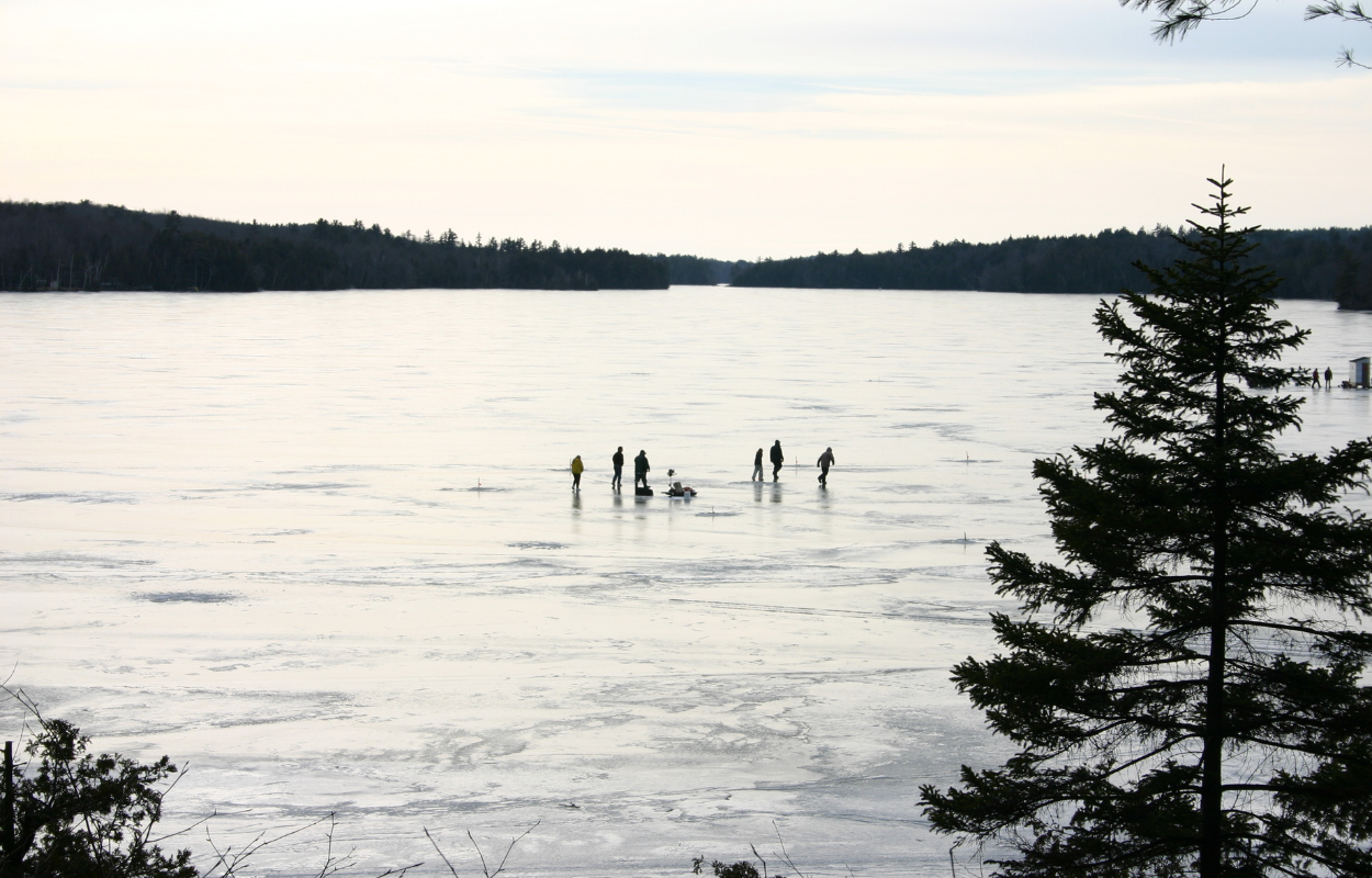 group of people ice fishing on a lake